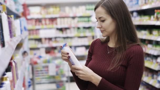 Mujer atractiva toma gel de ducha y olfatea en el supermercado, emoción y disgusto — Vídeos de Stock