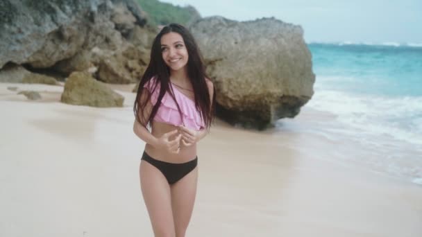 Lenti moti, ritratto di felice sorridente bella ragazza in costume da bagno poggiata sulla spiaggia, scatto steadicam — Video Stock