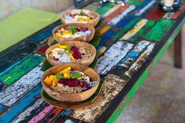 Dört smoothies kase kadar yakın mango, muz, granola, Hindistan cevizi rendesi, dragon meyve ile yapılmış, chia tohum ve nane renkli arka plan