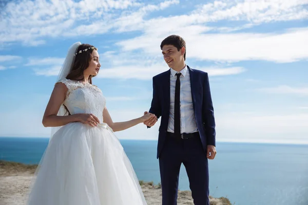 Retrato de feliz sonriente pareja de recién casados en la montaña con fondo marino —  Fotos de Stock