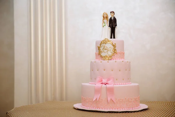 Auf einem Tisch steht eine mehrstöckige, mit Blumen dekorierte Hochzeitstorte. Konzept des Essens, Süßigkeiten und Desserts auf einer Party. — Stockfoto