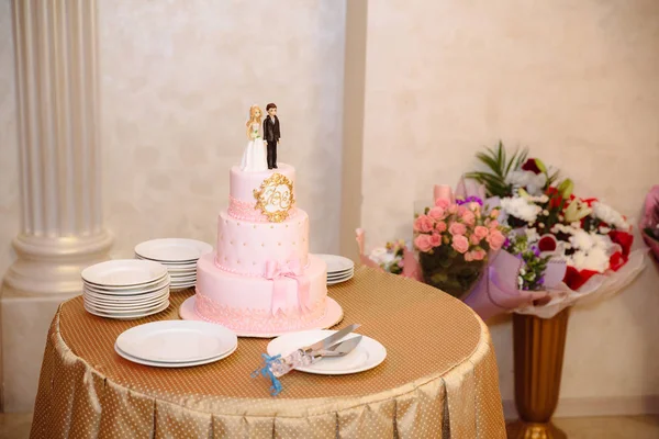 Многоуровневый свадебный торт, украшенный цветами, стоит на столе. Концепция еды, сладостей и десертов на вечеринке . — стоковое фото