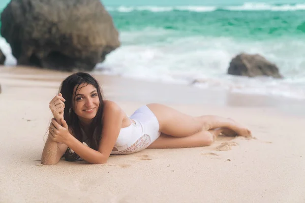 Sinnliches hübsches Mädchen im Badeanzug am weißen Sand am Strand liegend — Stockfoto