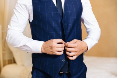 Close-up kadar tasarımcı onarım ile şık bir ofiste ayakta ceketinin düğmelerini bir iş şık adamı kırpılmış bir çerçeve.