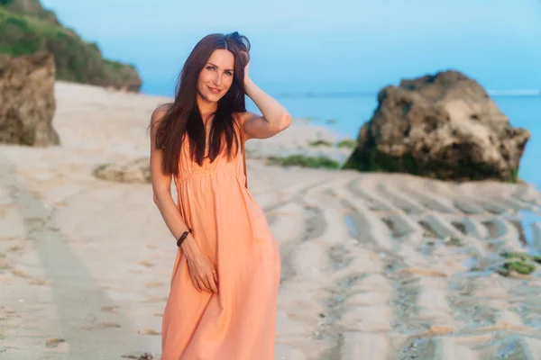 Hermosa chica feliz en sundress y con bolsa en correa larga posando en la playa de arena — Foto de Stock