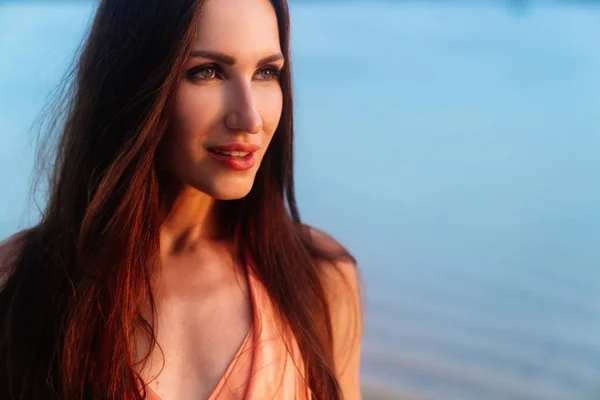 Primer plano retrato de hermosa chica morena con maquillaje en la puesta de sol en la playa del océano — Foto de Stock