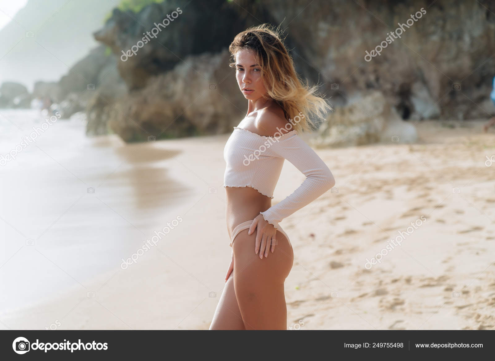 Slim sexy girl in beige top and bikini posing on tropical beach Stock Photo  by ©rmano.mail.ru 249755498
