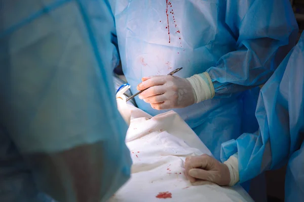 Mãos fechadas, equipe de doutores durante a cirurgia, instrumentos cirúrgicos em uma mesa — Fotografia de Stock