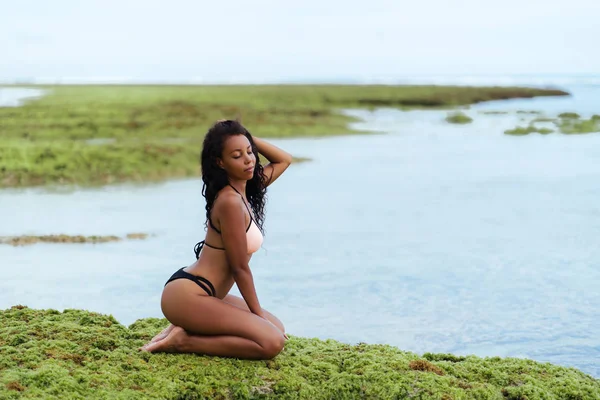 Modelo americano africano sexy em roupa de banho posando na praia. Menina de pele escura descansando na ilha trópica — Fotografia de Stock