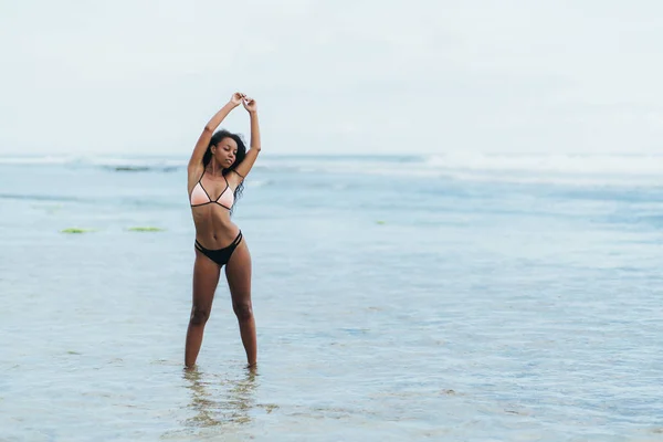 Hermosa chica de piel oscura en traje de baño descansando en la playa. Modelo afroamericano posando en isla tropical — Foto de Stock