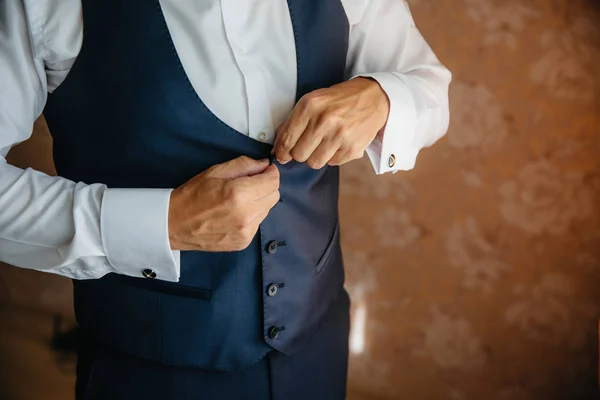Close-up homem elegante de negócios abotoando sua jaqueta, de pé em um escritório elegante com reparação designer . — Fotografia de Stock