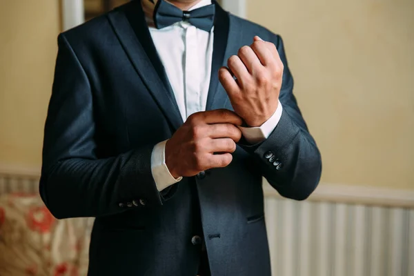 Close-up of a cropped frame of a business stylish man buttoning his jacket, standing in a stylish office with designer repair. — Stock Photo, Image