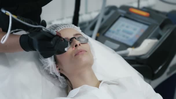 Close-up schoonheidsspecialist maakt laser vasculaire verwijdering op dames gezicht met speciale apparatuur — Stockvideo