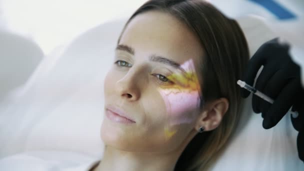 Közelkép cosmetologists kezében a fecskendőt teszi facial szépség injekciók womans arcán véna szkenner — Stock videók