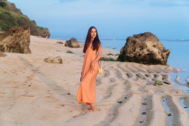 Sundress çanta uzun kayış ve tropik sahilde poz güneş gözlüğü ile çekici kız