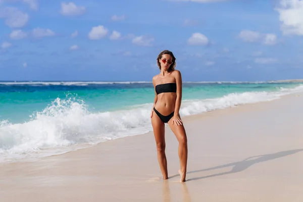 Ragazza con corpo sexy in costumi da bagno prende il sole sulla spiaggia di sabbia bianca — Foto Stock