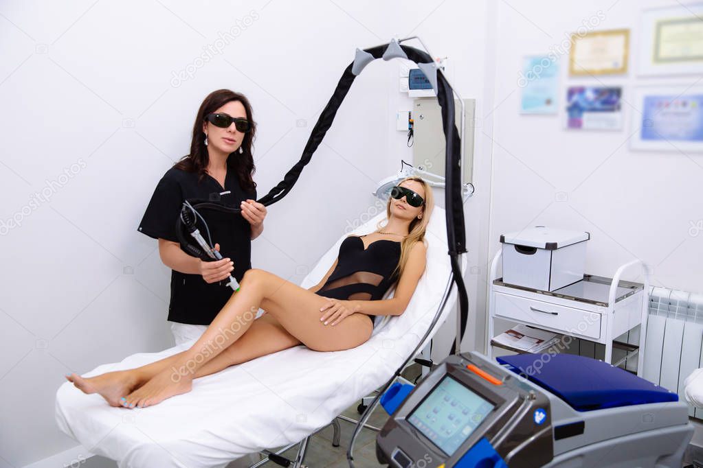Young beautiful woman on laser hair removal procedure in beauticians office