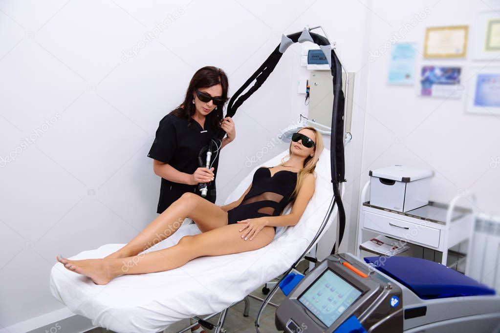 Young beautiful woman on laser hair removal procedure in beauticians office