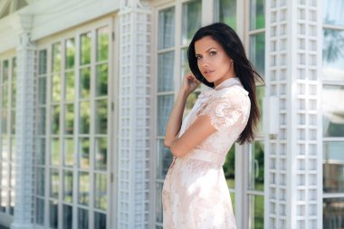 Bej renkli elbise café bir ahşap ve cam duvar dışında poz güzel esmer kız