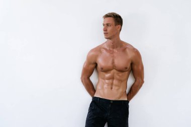 Beyaz arka plan üzerinde çıplak gövde ile seksi atletik erkek. Moda portre sportif sağlıklı adam