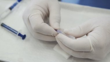 Yakın çekim doktorlar ellerini eldiven bir iğne şırıngadan tutar