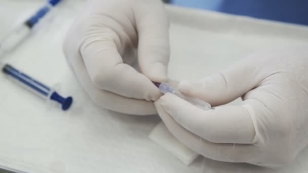 Close-up doctors hands in gloves holds a needle from syringe — Stock Video