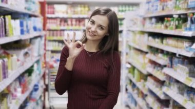 Avrupa kadın geniş bir gülümseme ile ok ya da mükemmel jest hızlı onu seviyor süpermarkette gösterir