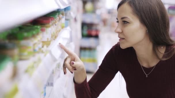 Portret kobiety patrzy na metki i szukasz produktu w supermarkecie — Wideo stockowe