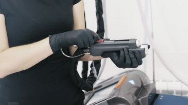 Yakın çekim güzellik uzmanı ellerinde eldiven lazer ekipmanları yordamı önce hazırlamak