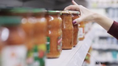 Kapatın rafları Cam Kavanoz süpermarket mal ile işçinin ürünler raf ticaret koyar