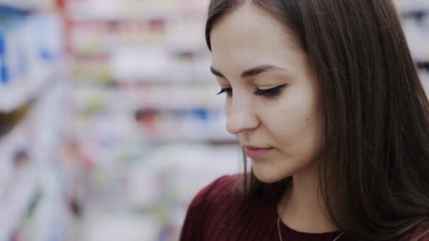 超市化妆品部女人嗅到沐浴露的近照, 喜欢它的情感 — 图库视频影像