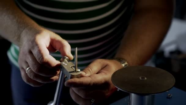 Zblízka, pracovník zaostřuje nůžky na nehty na grindstone, pomalý pohyb. — Stock video
