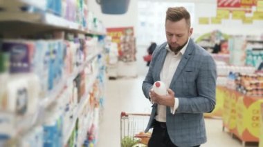 Süpermarkette ev eşyaları departmanında adam alışverişi.