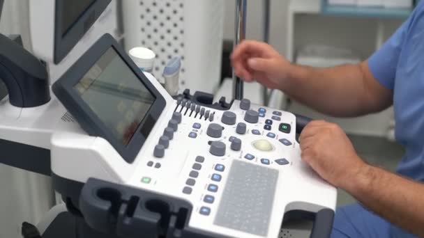 Cierre las manos del médico presiona botones y trabaja en el dispositivo de ultrasonido . — Vídeo de stock