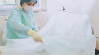 Hemşire ameliyat için hasta hazırlar, ameliyathaneye steril bir bebek bezi ile kapsar