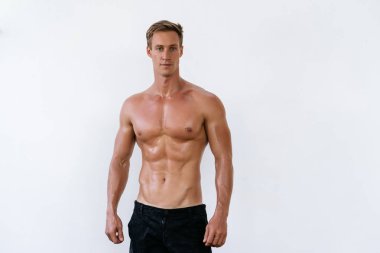Beyaz duvar arka plan üzerinde çıplak gövde ile seksi atletik erkek portresi