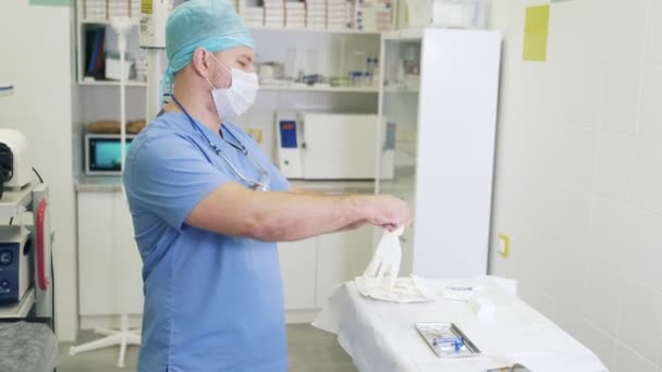 Médecin en vêtements stériles et masque met des gants avant la procédure de sclérothérapie . — Video