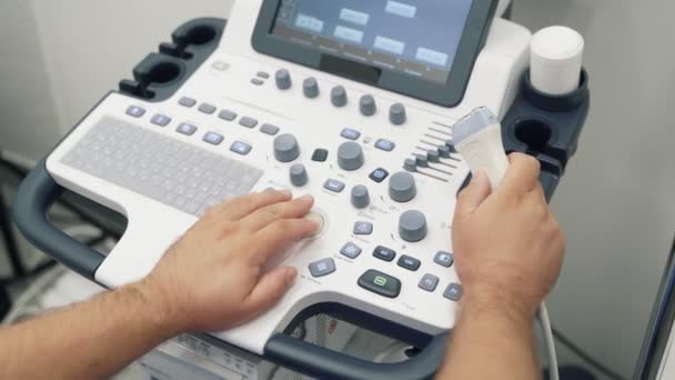 Close-up handen van Doctor werkt op echografie scanner. Medisch werknemer gebruik speciale apparatuur. — Stockvideo