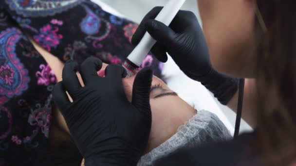 Руки крупным планом косметолога делают процедуры гидроочистки лица и пилинга на женском лице — стоковое видео