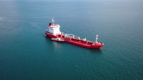 Vista aérea del buque cisterna rojo en el agua, buque remolcador cerca, entrada al puerto — Vídeos de Stock