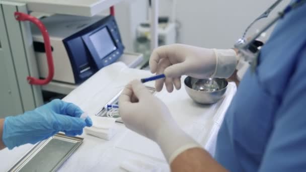 Les mains de docteur et d'infirmière de plan rapproché dans les gants stériles remplissent la seringue avec le medicament liquide. — Video