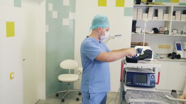 外科医は手術室の外科の前に無菌マスクおよび拡大の双眼鏡を置く — ストック動画