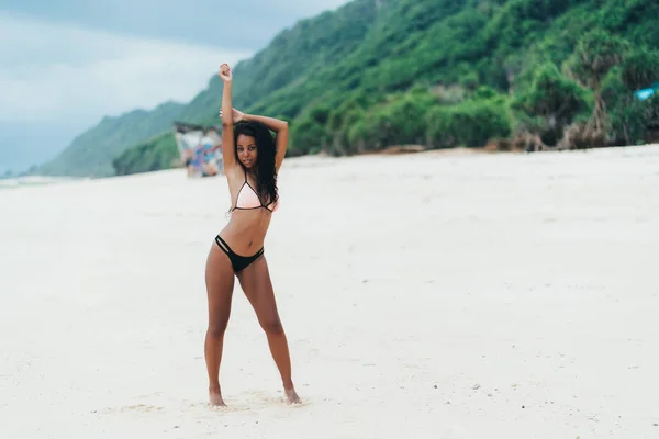 苗条性感的深色皮肤的女孩在泳衣摆姿势在沙滩上与沙子。在天堂岛上休息的非裔美国妇女 — 图库照片