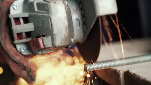 Slow motion mans hands cuts metal with a circular saw, sparks fly to the side. — Stock Video