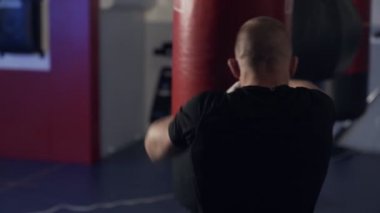 Arka görüş boksör adam bir kum torbası, yavaş hareket darbeler dışarı çalışıyor.