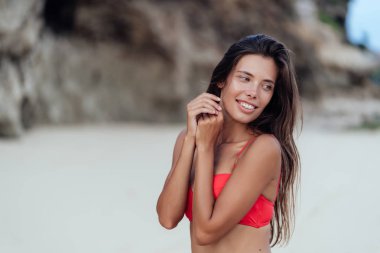 Kumlu plajda dinlenen renkli mayo seksi gülümseyen gezgin portresi