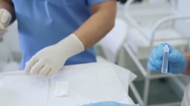 Steril eldivenlerde yakın çekim doktor ve hemşire elleri şırıngayı sıvı ilaçla dolduruyor.