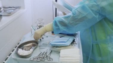 Steril giysi ve eldiven hemşiresi cerrahi önce enstrümanlar ve cerrahi tıbbi kapak hazırlar