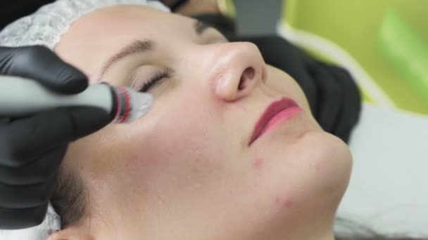 Close-up beautician hands makes hydro peeling and cleaning on patient face with special apparatus. — Stock Video