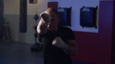 Spor salonunda kameraya yumruk atan adam boksör eğitimi, yavaş çekimde gölge kavgası. 